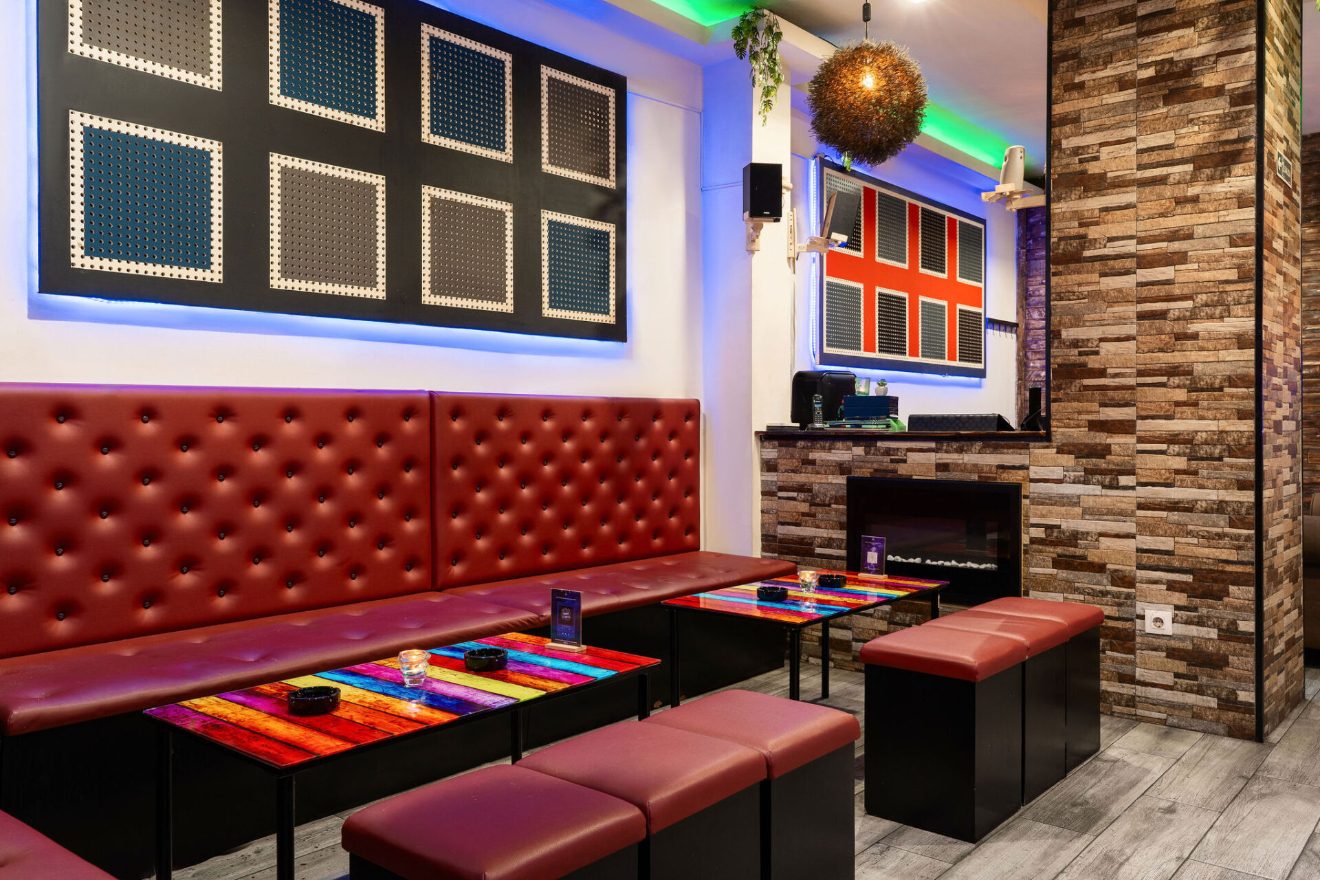 Zona lounge del club social cannábico Smoke Signals en Barcelona con luces de neón