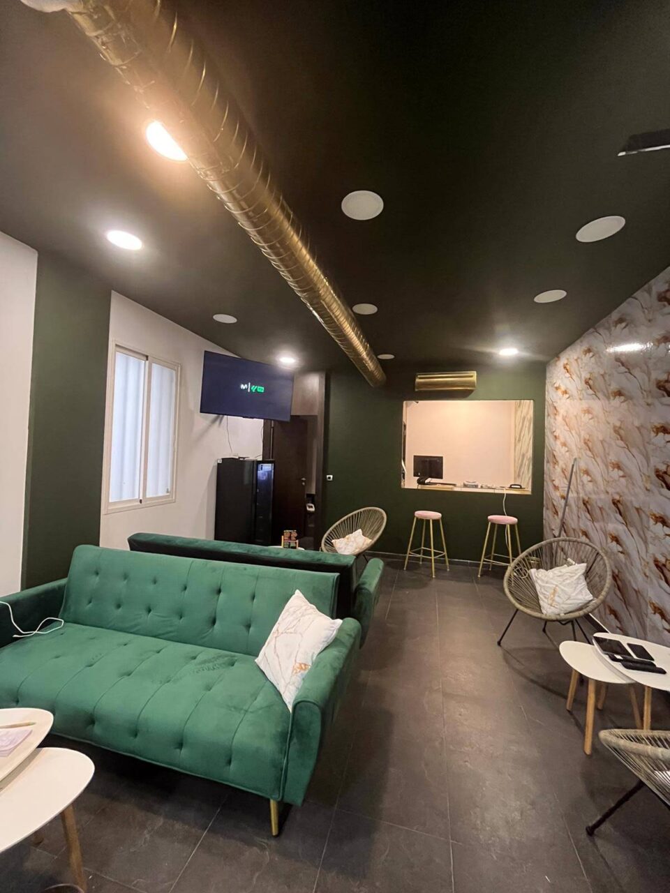 Sala principal de la asociación cannábica Green Paradise en Madrid con sofás verdes