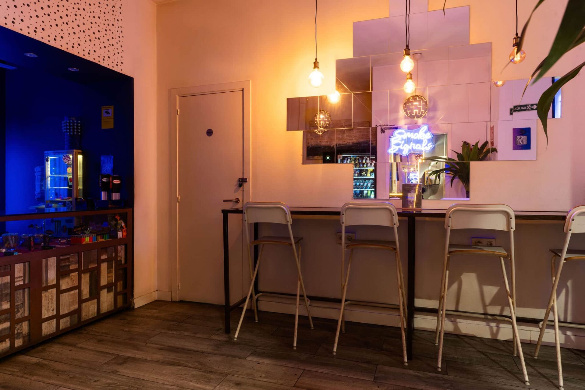 Barra con espejos y letrero de neón en el club de cannabis Smoke Signals de Barcelona